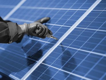 Engineer in a white helmet. Man near solar panel.